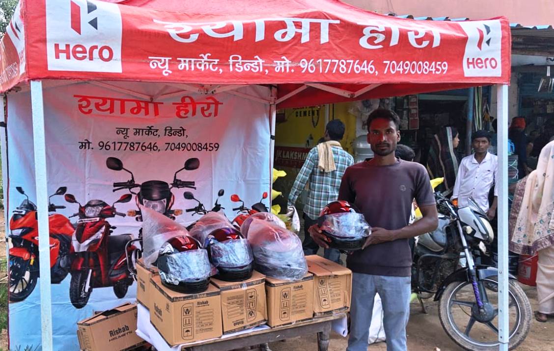 हाट-बाजारों में लगे हेलमेट स्टॉल, डिंडो साप्ताहिक बाजार में चार ग्रामीणों ने स्वप्रेरणा से खरीदे हेलमेट